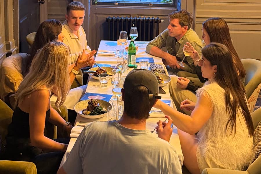 A Junto dinner in progress, guests talking around a long table